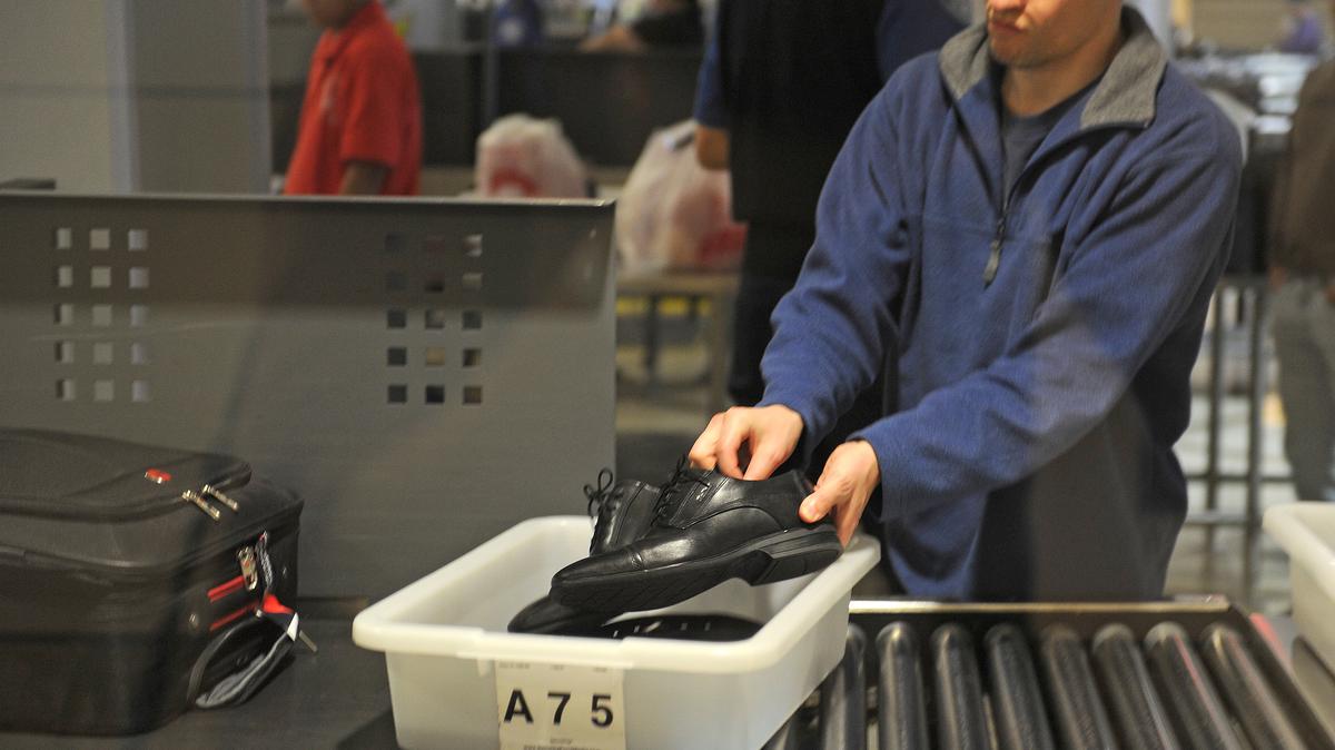 An air traveler places his shoes in a bin before passing through the Transportation Security Administration (TSA) security check at Los Angeles International Airport (LAX) on Feb. 20, 2014, in Los Angeles.