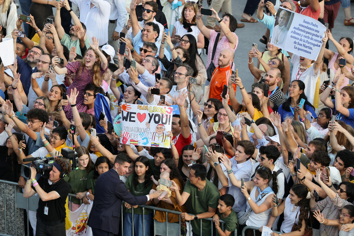 People hold mobile phones and signs as they gather for a prayer vigil with Pope Leo XIV (not pictured) at the Lluis Companys Olympic Stadium during his apostolic journey in Barcelona, Spain, June 9, 2026. REUTERS/Nacho Doce