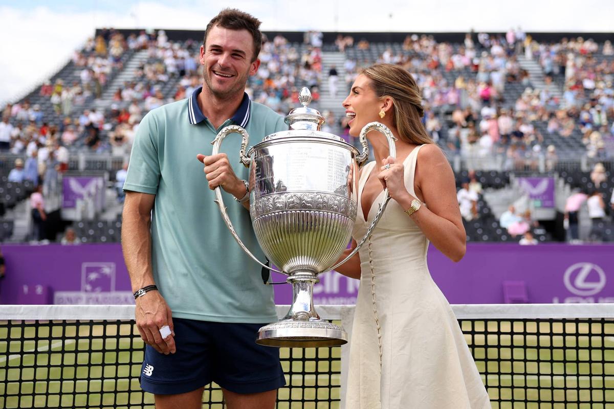  LONDON, ENGLAND - JUNE 23: Tommy Paul of United States and girlfriend, Paige Lorenze pose for a photo with the cinch Championships 2024 winners trophy following victory against Lorenzo Musetti of Italy in the Men's Singles Final match on Day Seven of the cinch Championship at The Queen's Club on June 23, 2024 in London, England. (Photo by Clive Brunskill/Getty Images) 