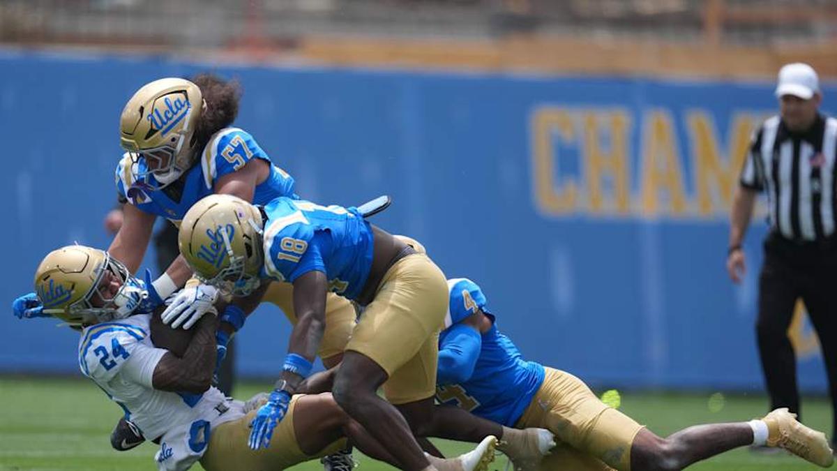  May 2, 2026; Pasadena, CA, USA; UCLA Bruins linebacker Matthew Muasau (57) and defensive backs Osiris Gilbert (18) and Cole Martin (4) tackle receiver Jonah Smith (24) during the spring game at Rose Bowl. Mandatory Credit: Kirby Lee-Imagn Images | Kirby Lee-Imagn Images 