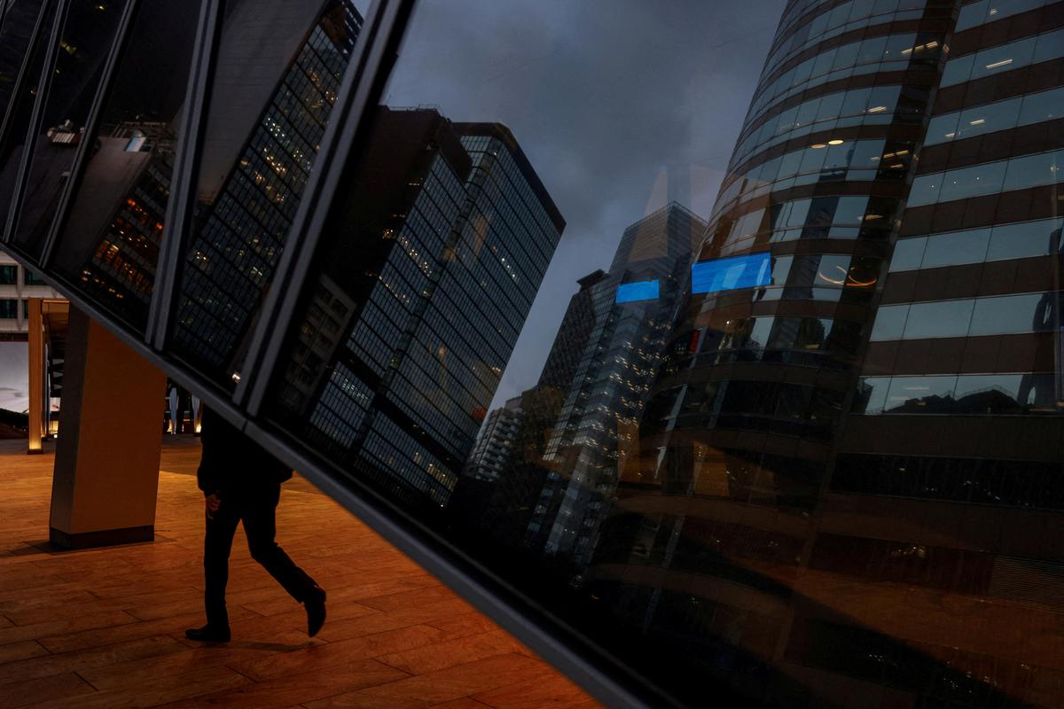 FILE PHOTO: A man walks through the Central business district in Hong Kong, China, February 24, 2025. REUTERS/Tyrone Siu/File Photo