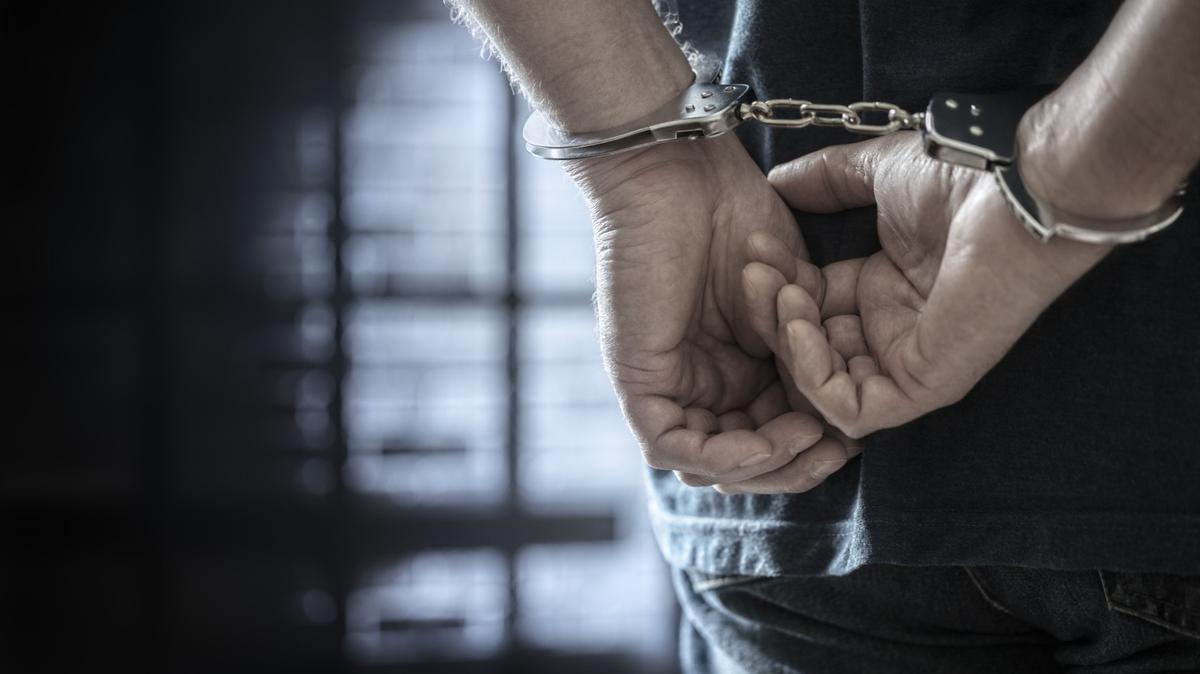 Persona detenida esposada. La policía de Miami detuvo a un menor de 14 años de edad y lo acusó de asesinato en segundo grado.
