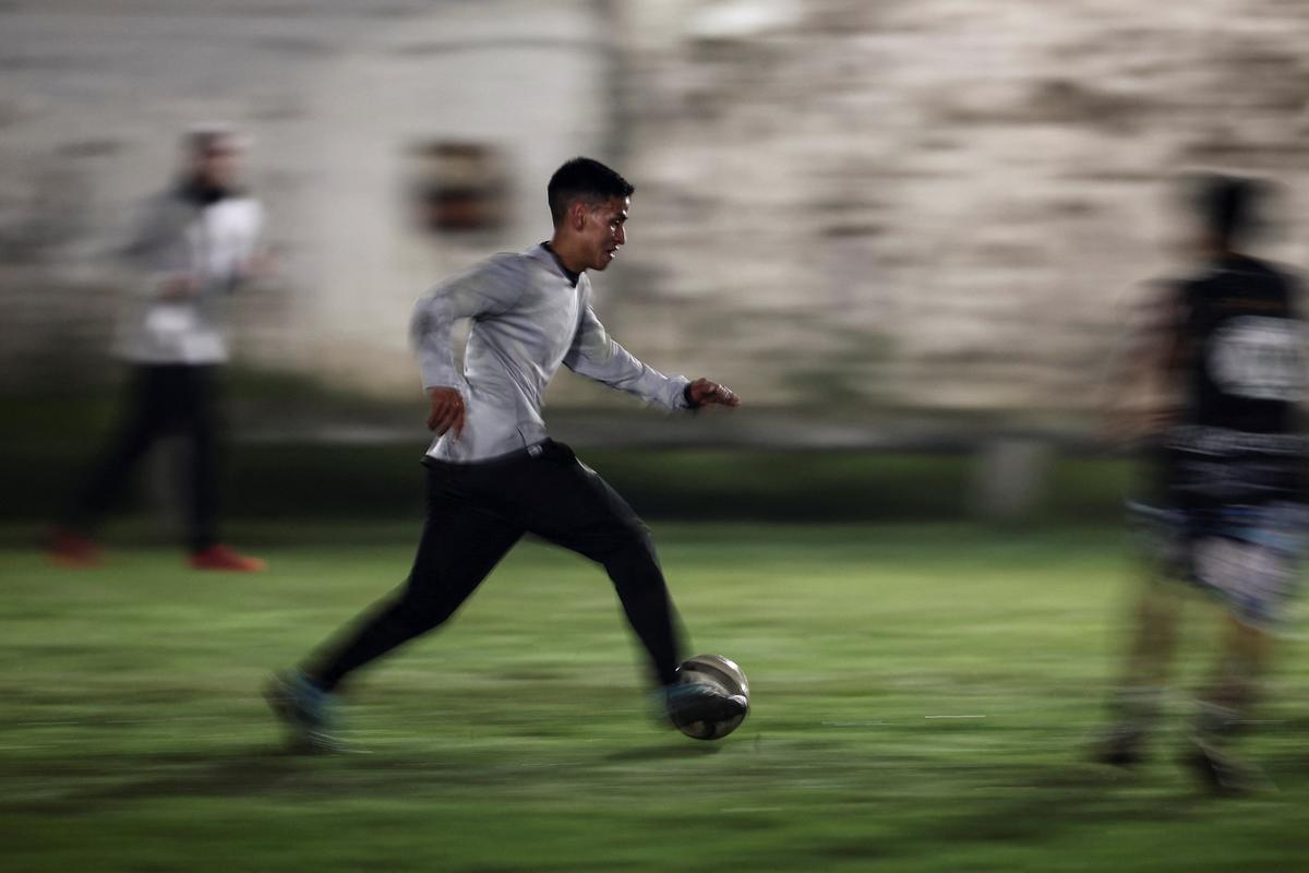 Emiliano Migueles, 26, drives the ball during an informal soccer match played for a cash prize of 300,000 Argentine pesos (215 USD), which is shared among players, in Ciudad Evita, on the outskirts of Buenos Aires, Argentina, April 9, 2026. At a recent match where his team won, some 300,000 pesos (215 USD) was paid out. But Migueles, who didn't place any bets, received only his 17,000 pesos (12 USD) pay for playing. "I mostly don't bet because I'm always short on cash, that's the reality," he said. "Betting isn't something that appeals to me. I love the street games for everything they are, the adrenaline, everything they give you," he said. REUTERS/Agustin Marcarian
