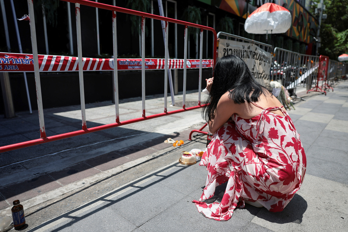 A woman visits the Rong Beer Na Lat Phrao bar to pay tribute to victims who lost their lives in the bar fire, the day after the incident, in Bangkok, Thailand, July 14, 2026. REUTERS/Chalinee Thirasupa