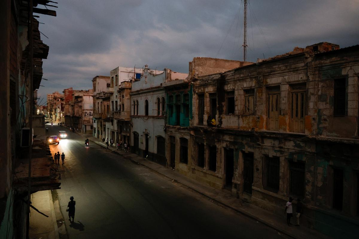 People walk along San Lazaro Avenue during a blackout as Cuba's state-run economy has descended into a full-blown crisis after the administration of U.S. President Donald Trump hardened sanctions and cut off the Caribbean nation's oil supply, in Havana, Cuba, May 6, 2026. REUTERS/Norlys Perez