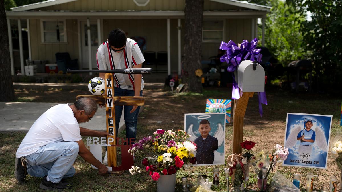 José Mata (de pie), hermano de Xavier López, y un hombre que se negó a dar su nombre, colocan una cruz de madera decorada con un bate de béisbol en un monumento en honor a su hermano frente a su casa en Uvalde, Texas, el martes 31 de mayo de 2019. 2022. López fue uno de los estudiantes asesinados en el tiroteo del 24 de mayo en la Escuela Primaria Robb. (Foto AP/Jae C. Hong)