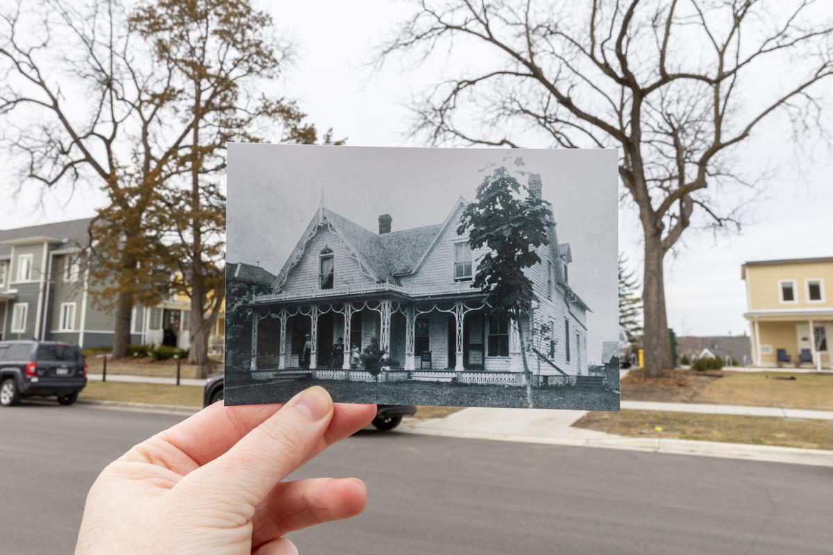 A photograph of the orginial Dacie Moses House, now Carleton College's cookie house, is held up outside the house in Northfield, Minn., March 31, 2026. Decades ago, before a recent renovation, students would sleep on the porch of the Dacie Moses house. (Liam James Doyle/The New York Times)