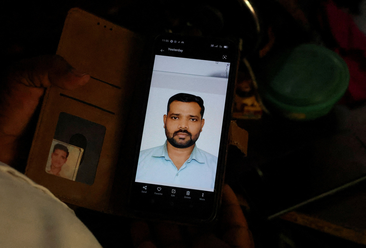 Sanjay Chaurasia, brother-in-law of Shivanand Chaurasia, an Indian seafarer aboard the Palau-flagged tanker MT Settebello, who was among three crew members killed in one of the U.S. attacks on Indian-crewed tankers this week amid a blockade of Iran-related shipping, shows a picture of Shivanand on his phone in Deoria, Uttar Pradesh, India, June 12, 2026. REUTERS/Priyanshu Singh