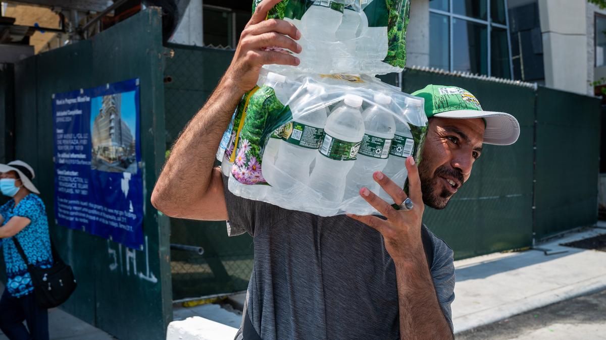 A vendor carries a cases of water at Coney Island on a sweltering afternoon on the first weekend of summer on Saturday, June 22, 2024, in New York. Dramatic temperature jumps marked the March and April of 2026 in the U.S. Northeast, making it hard to know what to dress for: chilly or sweltering conditions?(Spencer Platt/Getty Images/TNS)