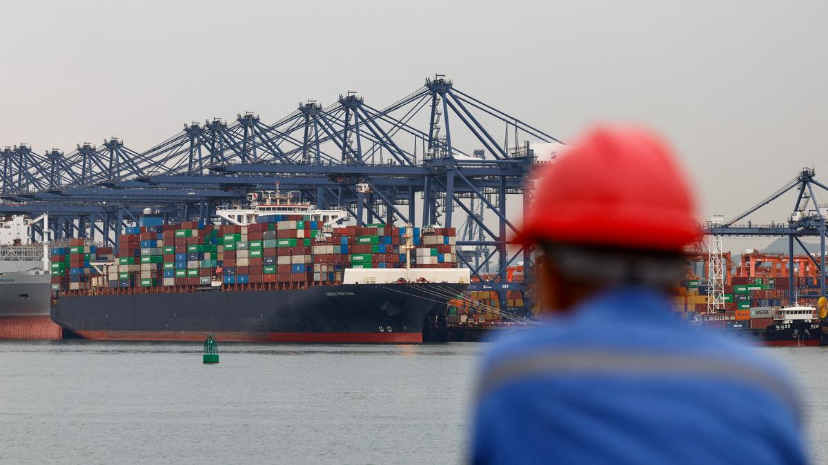 A worker looks on near a cargo ship carrying containers at the Yantian port in Shenzhen, Guangdong province, China May 9, 2025. REUTERS/Tingshu Wang