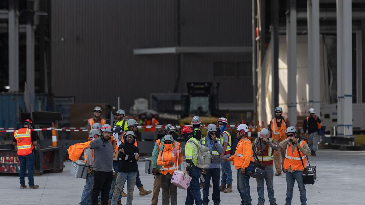 FILE PHOTO: Workers leave a SpaceX construction site as the company prepares to file for an initial public offering (IPO), in Starbase, Texas, U.S., April 22, 2026. REUTERS/Carlos Barria/File Photo