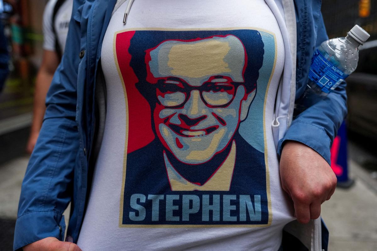 FILE PHOTO: A person wears a t-shirt with an image of Stephen Colbert outside of the Ed Sullivan Theater where the last show of Stephen Colbert’s Late Show is filmed, in New York City, U.S., May 21, 2026. REUTERS/Adam Gray/File Photo