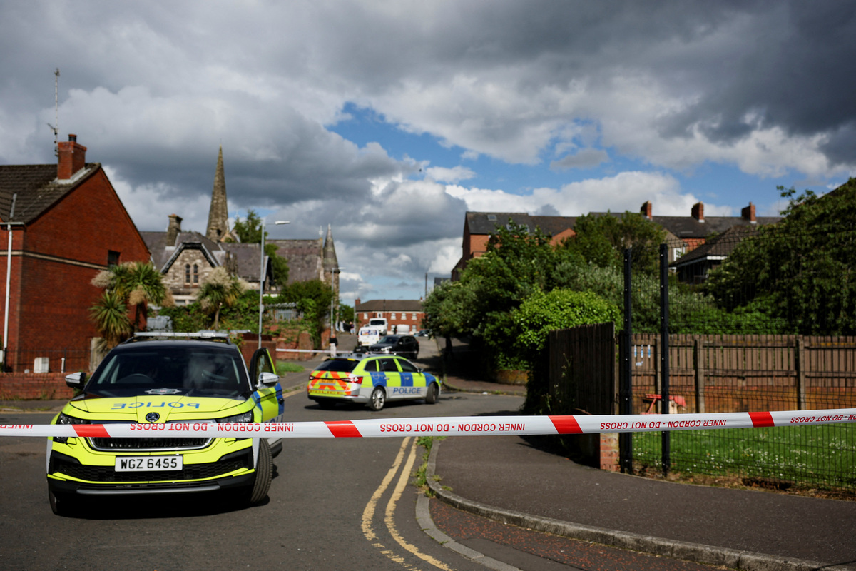 Police vehicles sit near a cordon at the scene of a stabbing outside apartments in the Kinnaird Avenue area of north Belfast, after a knife attack on June 8 left a man seriously injured and prompted police to declare a critical incident, in Belfast, Northern Ireland, June 9, 2026. REUTERS/Isabel Infantes