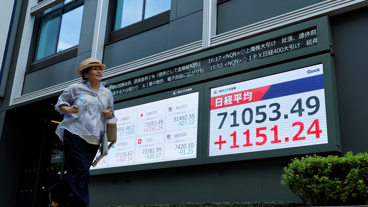 A pedestrian runs past a stock quotation board showing the Nikkei share average outside a brokerage in Tokyo, Japan, June 18, 2026.    REUTERS/Kim Kyung-Hoon