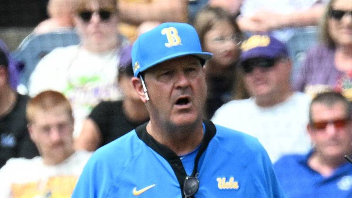  Jun 17, 2025; Omaha, Neb, USA; UCLA Bruins head coach John Savage (22) discusses a call with the plate umpire during the game against the LSU Tigers during the seventh inning at Charles Schwab Field. Mandatory Credit: Steven Branscombe-Imagn Images | IMAGN IMAGES via Reuters Connect 