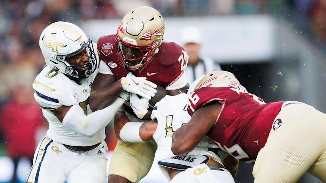  Aug 24, 2024; Dublin, IRL; Florida State University running back Roydell Williams is tackled by Trenilyas Tatum and Kyle Efford of Georgia Tech at Aviva Stadium. Mandatory Credit: Tom Maher/INPHO via Imagn Images | Tom Maher/INPHO via Imagn Images 