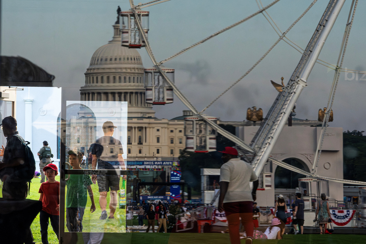 The U.S. Capitol building and Freedom 250 Wheel are reflected on a glass door as people attend the Great American State Fair on the National Mall in Washington, D.C., U.S., June 25, 2026. REUTERS/Nathan Howard