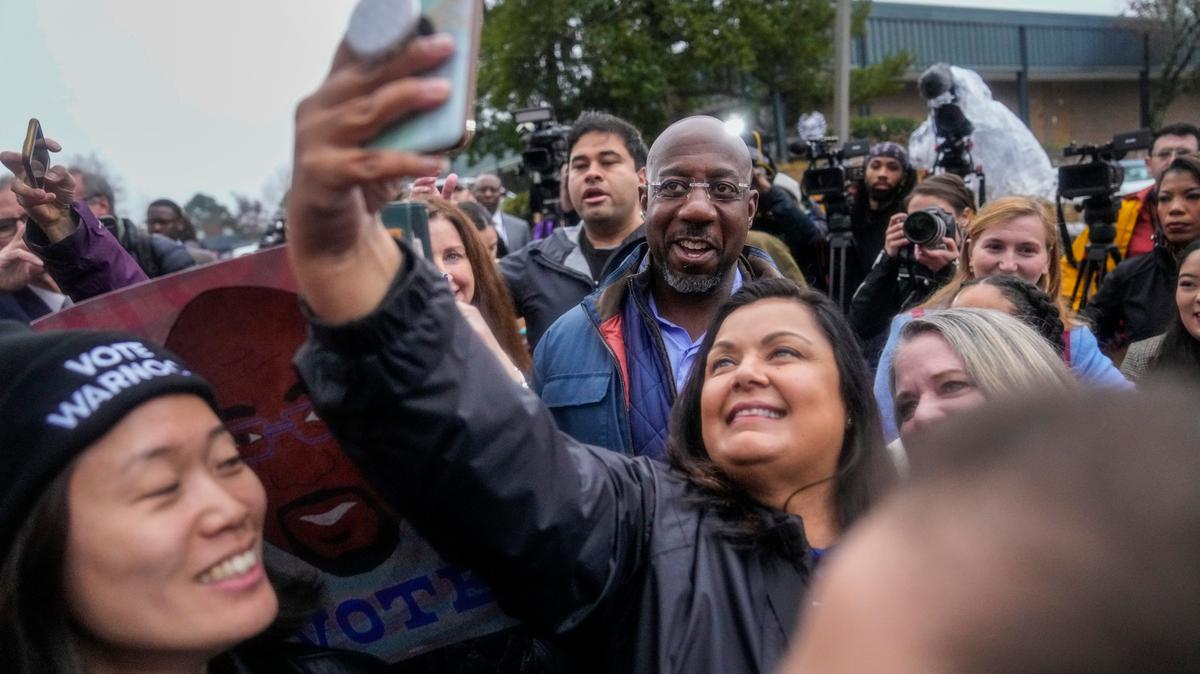 El senador demócrata Raphael Warnock posa con sus partidarios el día de las elecciones, el martes 6 de diciembre de 2022 en Norcross, Georgia. (Foto AP/Brynn Anderson)