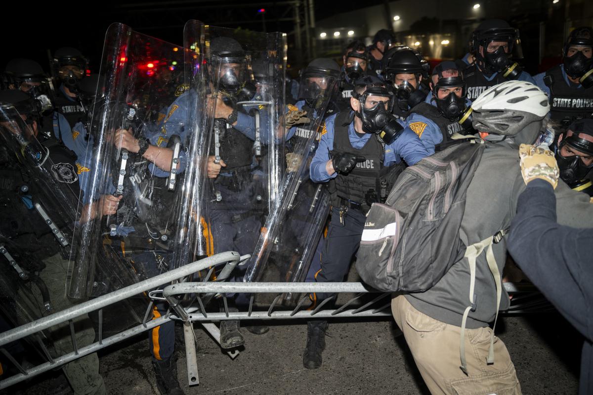 Demonstrators and police officers outside the Delaney Hall immigration detention center in Newark, N.J., May 30, 2026. Mayor Ras Baraka of Newark imposed a curfew early Sunday around the immigration detention center after a second consecutive night of unrest over living conditions there. (Vincent Alban/The New York Times)