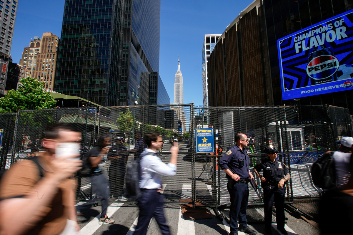 New York Police Department officers stand guard next to a security fence as people walk outside of Madison Square Garden ahead of Game three of the NBA Finals between the New York Knicks and San Antonio Spurs at Madison Square Garden in New York City, U.S., June 8, 2026.  REUTERS/Eduardo Munoz
