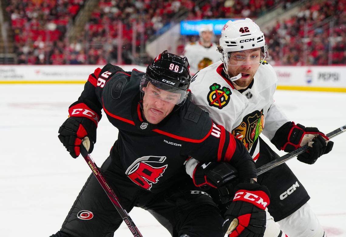 Carolina Hurricanes right wing Mikko Rantanen (96) and Chicago Blackhawks defenseman Nolan Allan (42) battle for the puck during the third period at Lenovo Center.