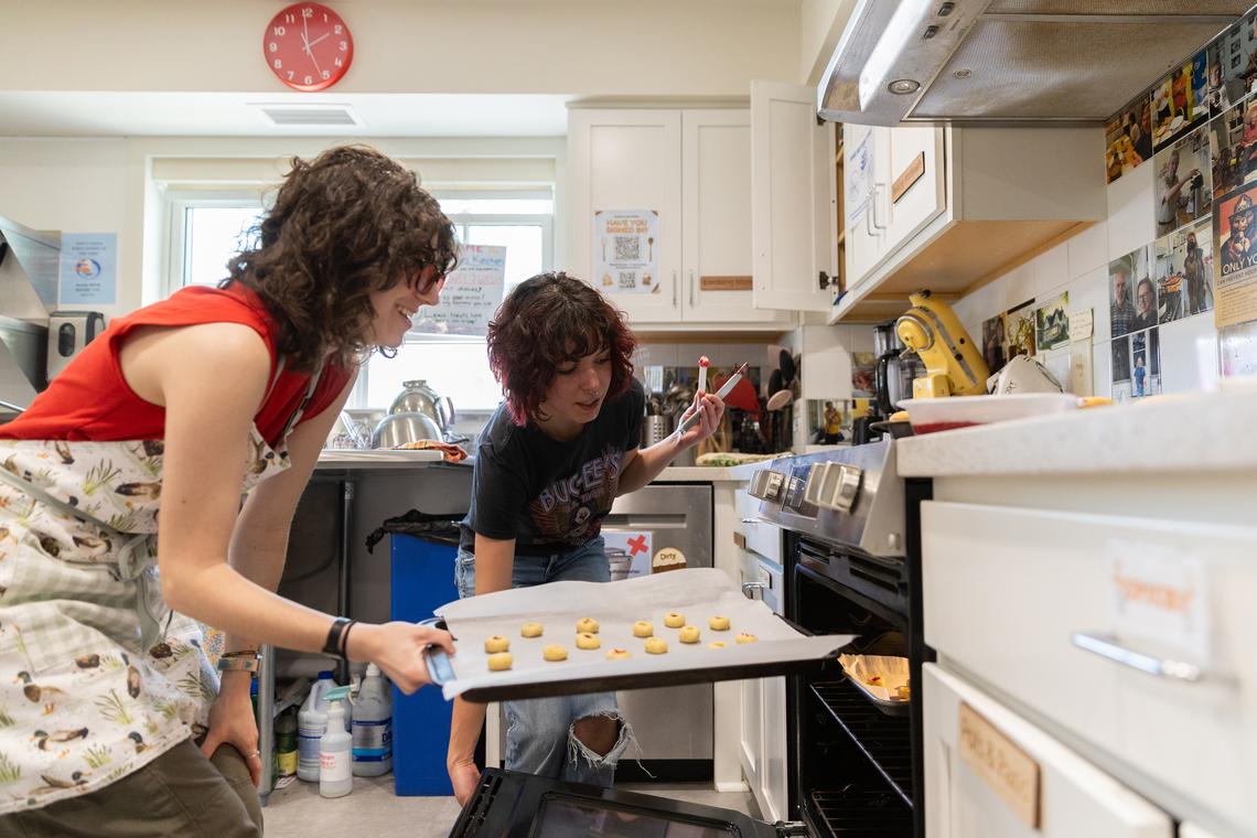 Annie Rogovin, left, and Maya Allen tending to Rogovin's butter cookies at the Dacie Moses House, Carleton College's cookie house in Northfield, Minn., March 30, 2026. For decades, Carleton College has kept a place where students and others can come, bake and share. (Liam James Doyle/The New York Times)