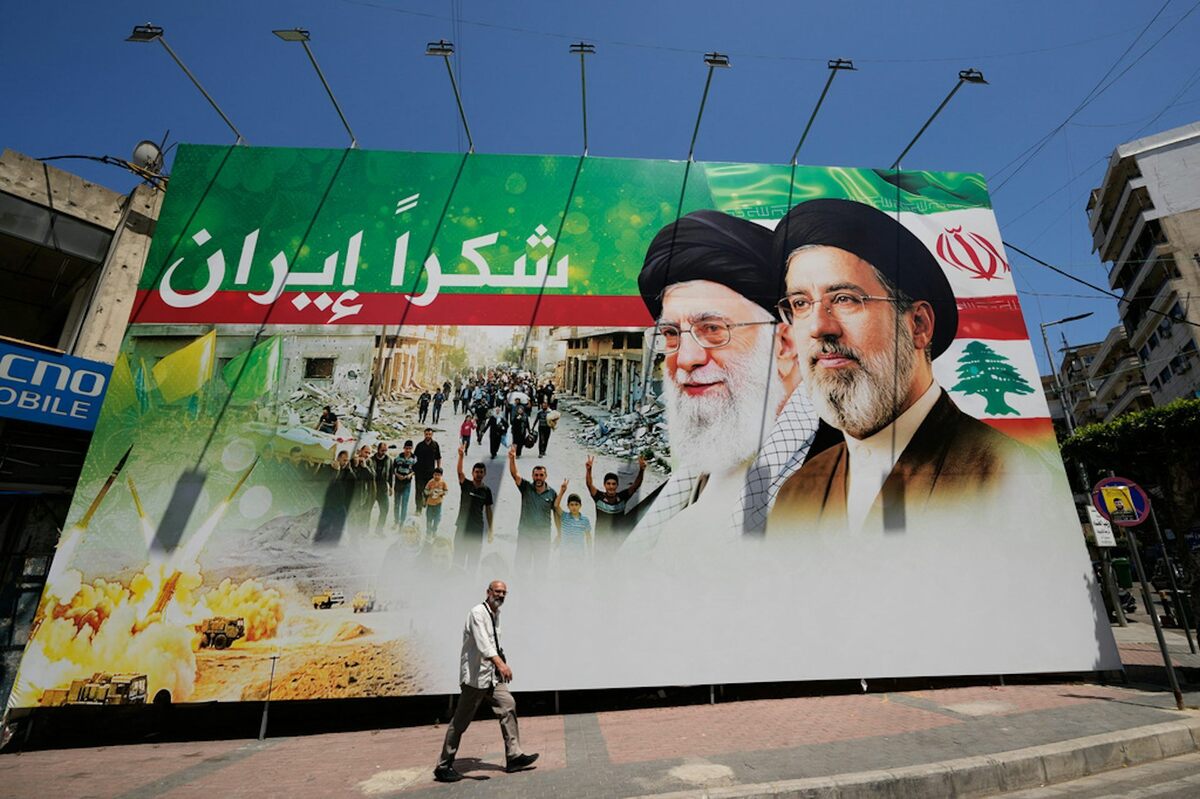  A man passes by a giant billboard in south Beirut that shows the late Iranian leader Ayatollah Ali Khamenei, center, and Iranian Supreme Leader Ayatollah Mojtaba Khamenei, with Arabic writing that reads: ‘Thank you Iran.' AP Photo/Hussein Malla 