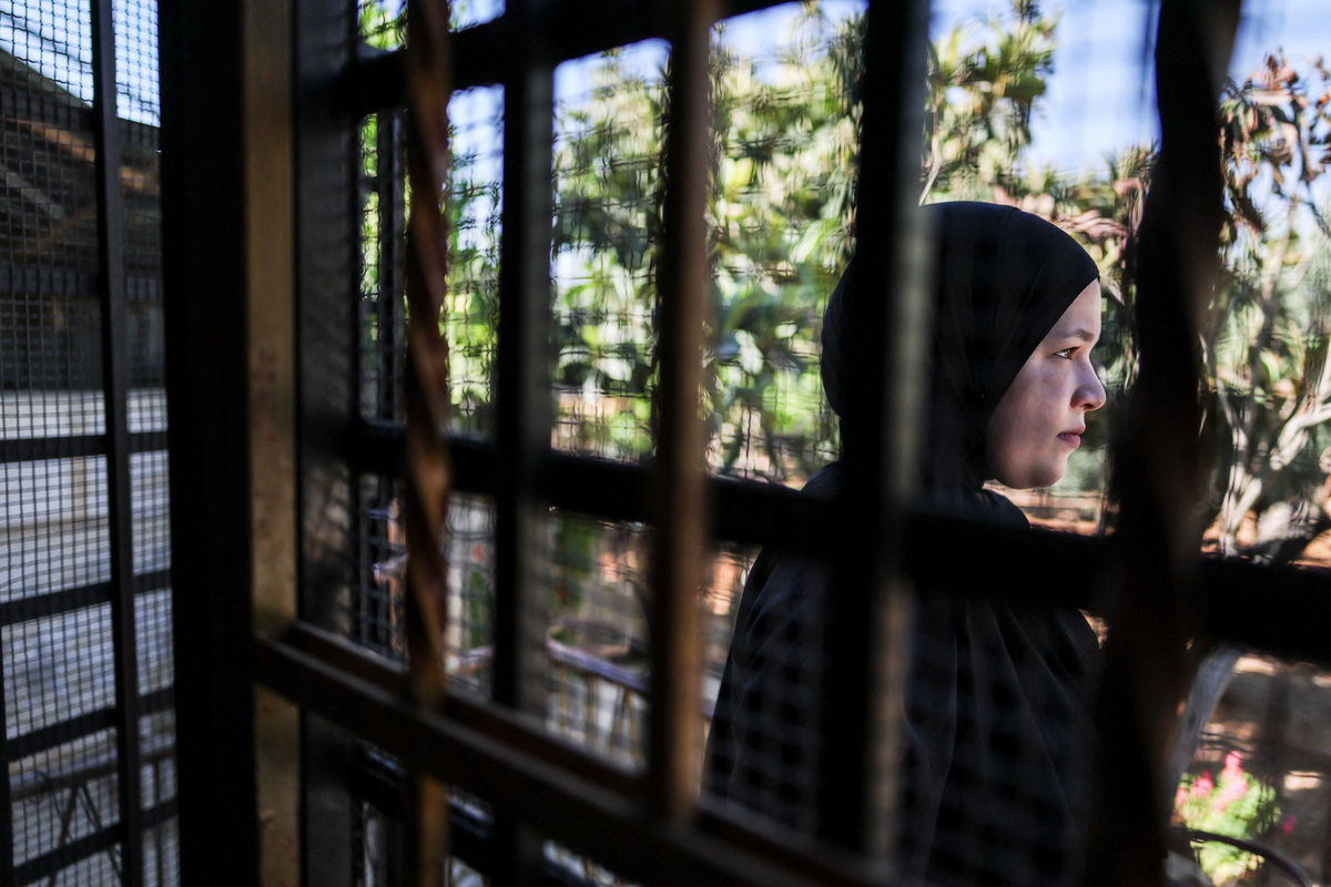 Amal Foqahaa, 13, stands outside her family home, whose windows they barred after Israeli settlers threw a Molotov cocktail inside two years ago while the family was home, in Sinjil, near Ramallah, in the Israeli-occupied West Bank, June 26, 2026. REUTERS/Ammar Awad
