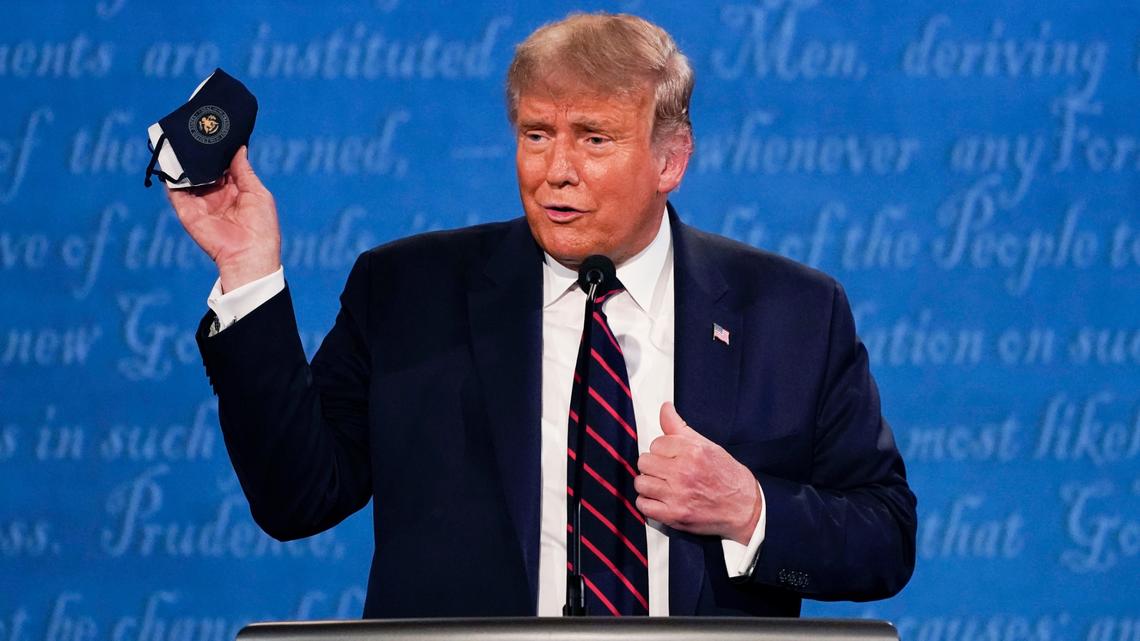 In this Sept. 29, 2020, file photo, President Donald Trump holds up his face mask during the first presidential debate.