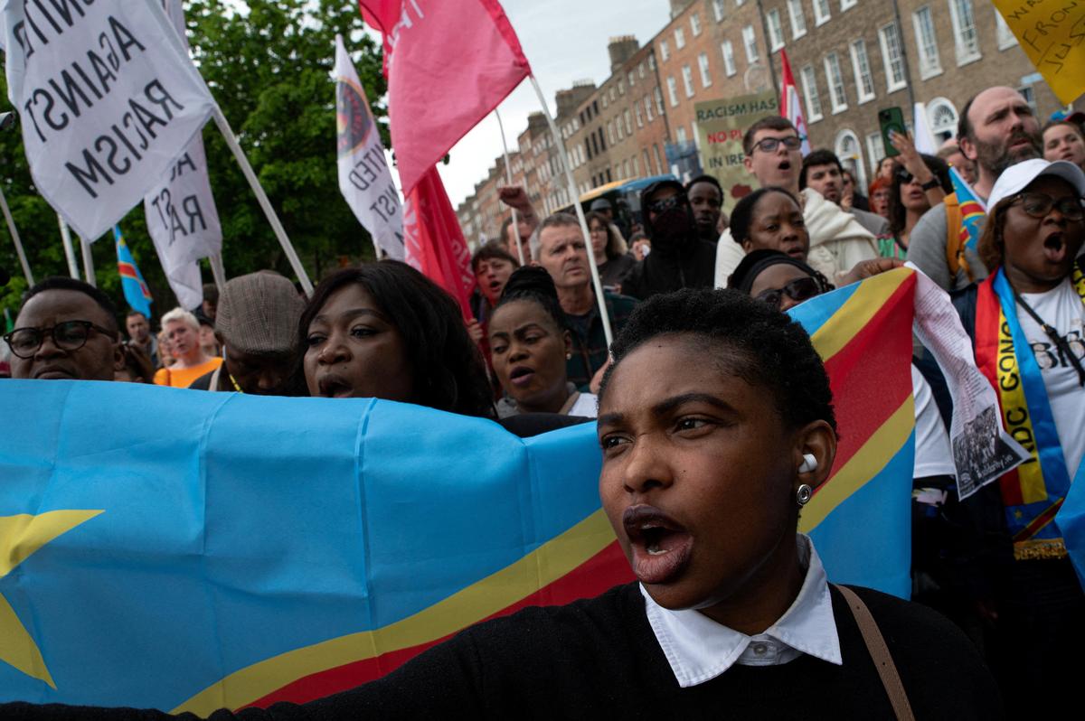 People hold flags during a protest following the death of Yves Sakila, a Congolese-born man who died after being restrained by security guards outside a department store, outside Leinster House in Dublin, Ireland, May 21, 2026. REUTERS/Natalia Campos