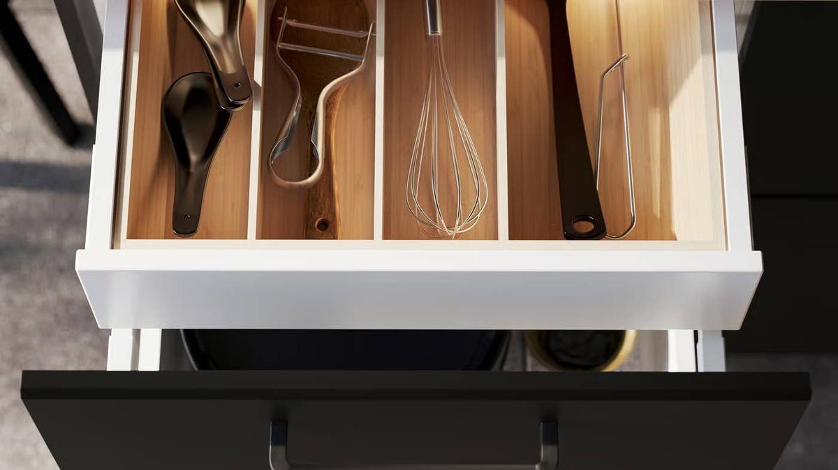 Open kitchen drawer with cooking utensils.