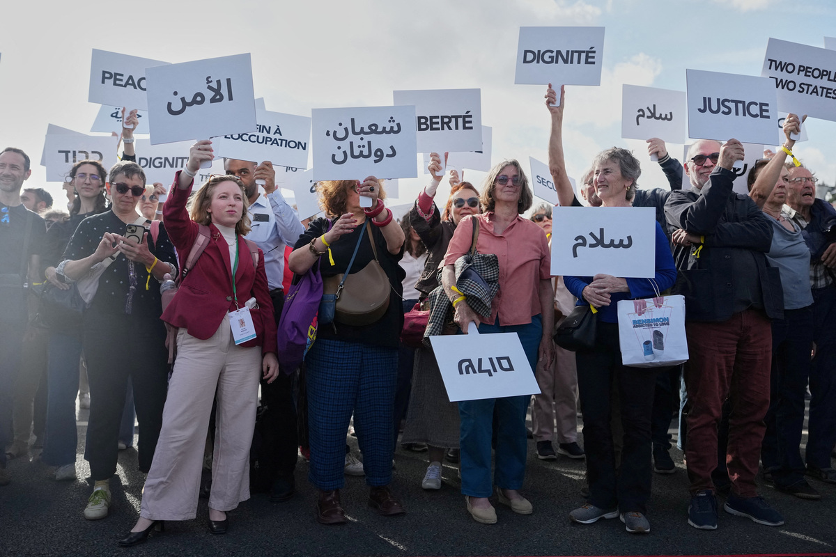 Participants in a conference with Israeli and Palestinian civil society groups supporting a two-state solution gather with placards on a bridge in support of a Palestinian state, in Paris, France, June 12, 2026. Thibault Camus/Pool via REUTERS