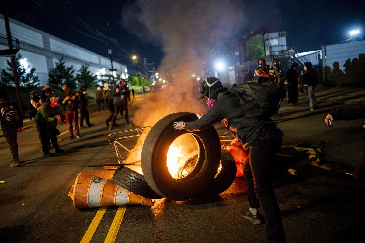 Demonstrators set debris on fire outside the Delaney Hall immigration detention center in Newark, N.J., May 30, 2026. Mayor Ras Baraka of Newark imposed a curfew early Sunday around the immigration detention center after a second consecutive night of unrest over living conditions there. (Vincent Alban/The New York Times)