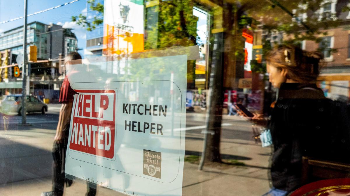 A help wanted sign hangs in a bar window along Queen Street West in Toronto Ontario, Canada June 10, 2022. REUTERS/Carlos Osorio