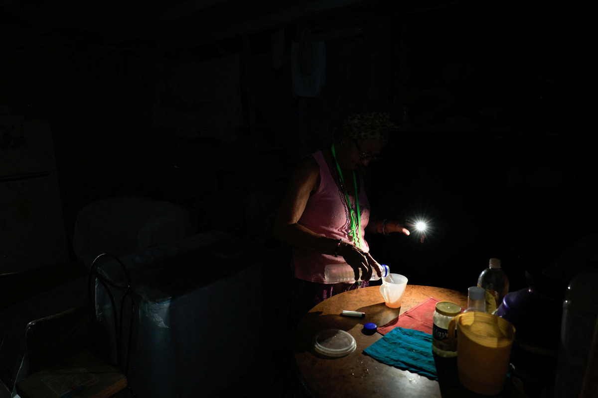 Retired nursing assistant Ana Amelia Gracias, 70, pours herself water at home as Cuba's national electric grid collapsed at midday, leaving around 10 million people without power, in Havana, Cuba July 6, 2026. REUTERS/Norlys Perez