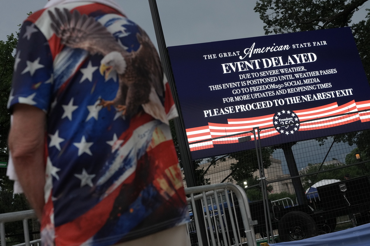 A sign notes weather delays for America 250 events, at the National Mall in Washington on July 4, 2026. Though it was muggy and miserably hot in many parts of the country, the day was marked with the usual American exuberance, with fighter jets, tall ships, parachutists and flag-festooned pick-up trucks. (Alex Kent/The New York Times)