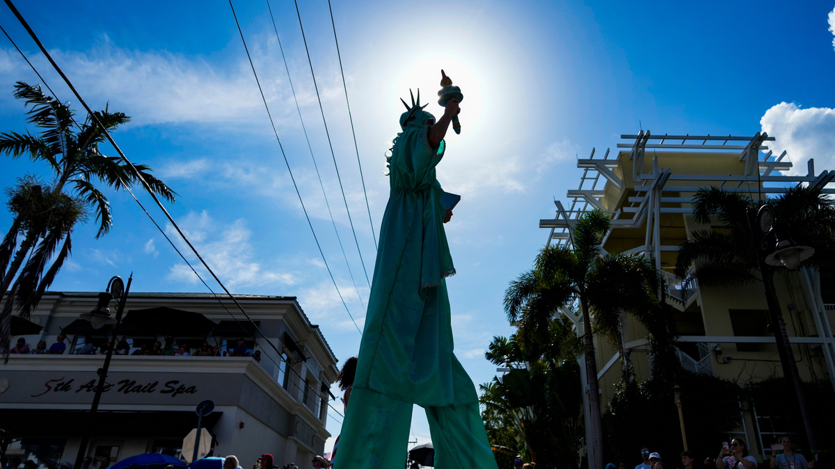 A Citrus Circus performer dressed as the Statue of Liberty take part during a July Fourth parade on Fifth Avenue South in Naples, Fla., on Saturday, July 4, 2026.