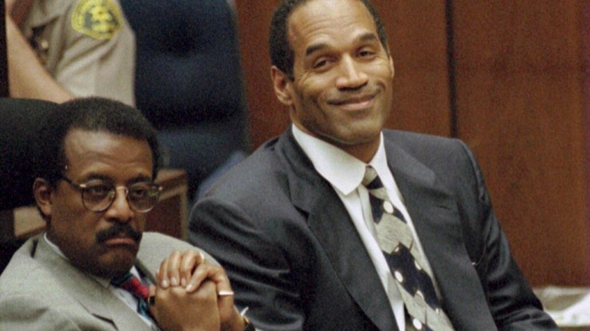 Lead defense attorney Johnnie Cochran (L) and defendant O.J. Simpson listen to testimony on March 21, 1995, by Brian "Kato" Kaelin as Simpson smiles. Kaelin was a guest at Simpson's Rockingham mansion at the time of the murder of Nicole Brown Simpson and Ronald Goldman on this day in 1994. File Photo by Myung J. Chun/pool/UPI