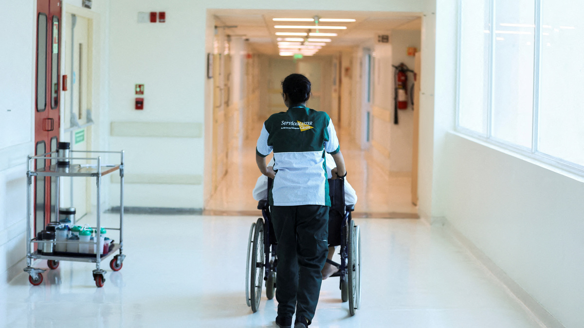 FILE PHOTO: An attendant wheels a patient at a hospital in New Delhi, India, June 22, 2023. REUTERS/Anushree Fadnavis/File Photo