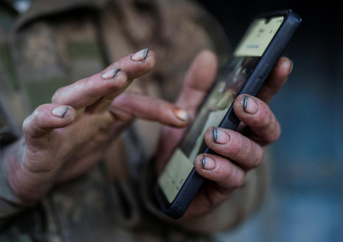 FILE PHOTO: Andrii, a serviceman of the 93rd Kholodnyi Yar Separate Mechanized Brigade of the Ukrainian Armed Forces uses a mobile phone after returning from a frontline position after manning it for about half a year, amid Russia's attack on Ukraine, in Donetsk region, Ukraine April 29, 2026. REUTERS/Serhii Korovainyi/File Photo