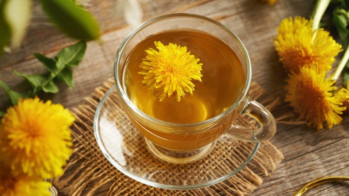 A glass cup of dandelion tea on a wooden table. Herbal medicine.