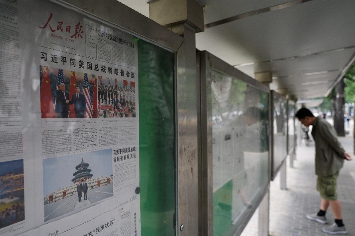 Newspapers with images of Chinese President Xi Jinping meeting U.S. President Donald Trump at the Great Hall of the People on the front page are displayed at a billboard, in Beijing, China May 15, 2026. REUTERS/Tingshu Wang