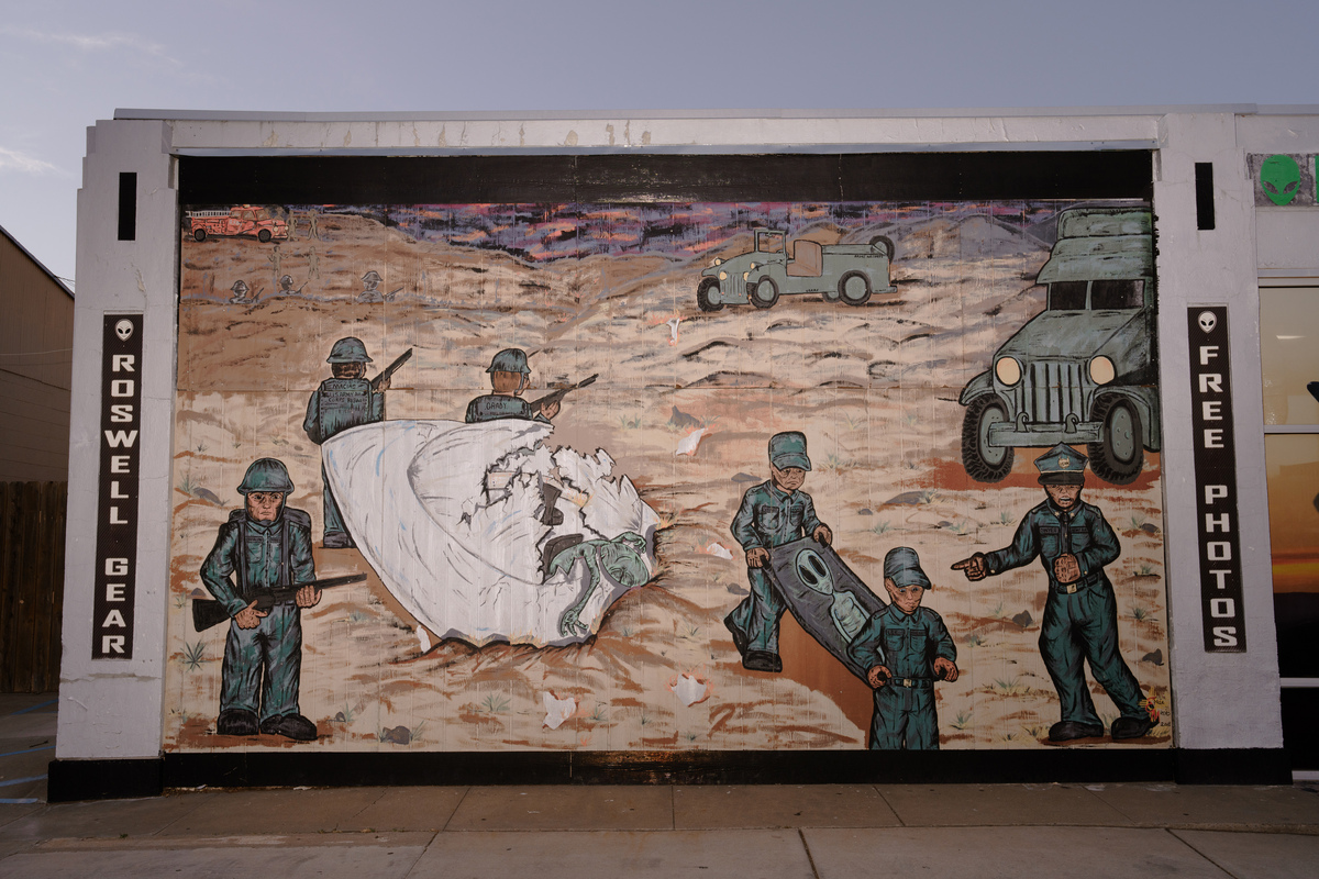 A mural of the Roswell UFO crash is painted on the Invasion Station gift shop in Roswell, N.M, July 3, 2026. Downtown Roswell streetlights are painted to look like aliens and little green men stand sentry outside carwashes and banks, all a homage to the purported UFO crash in 1947 known as the Roswell Incident. (Paul Ratje/The New York Times)