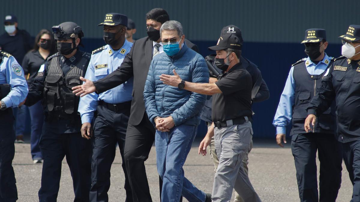 Foto de archivo. El expresidente hondureño Juan Orlando Hernández, centro, es llevado esposado a un avión para ser extraditado a Estados Unidos, en una base de la Fuerza Aérea en Tegucigalpa, Honduras, el jueves 21 de abril de 2022.