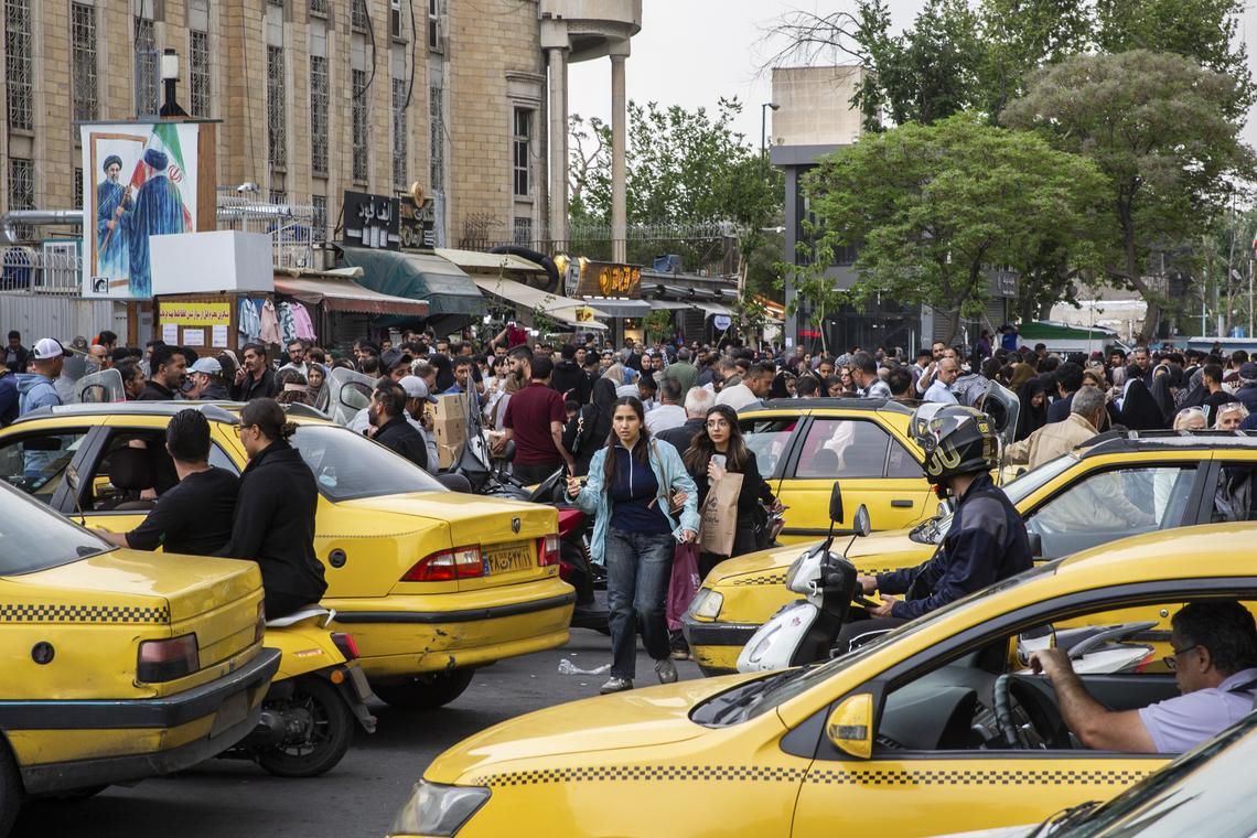 People people cross a street packed with taxi cabs in Tehran, on Monday, April 20, 2026. Despite sending mixed signals in recent days, both the United States and Iran gave clearer indications on Monday that they were planning to send negotiators to peace talks in Pakistan this week. (Arash Khamooshi/The New York Times)