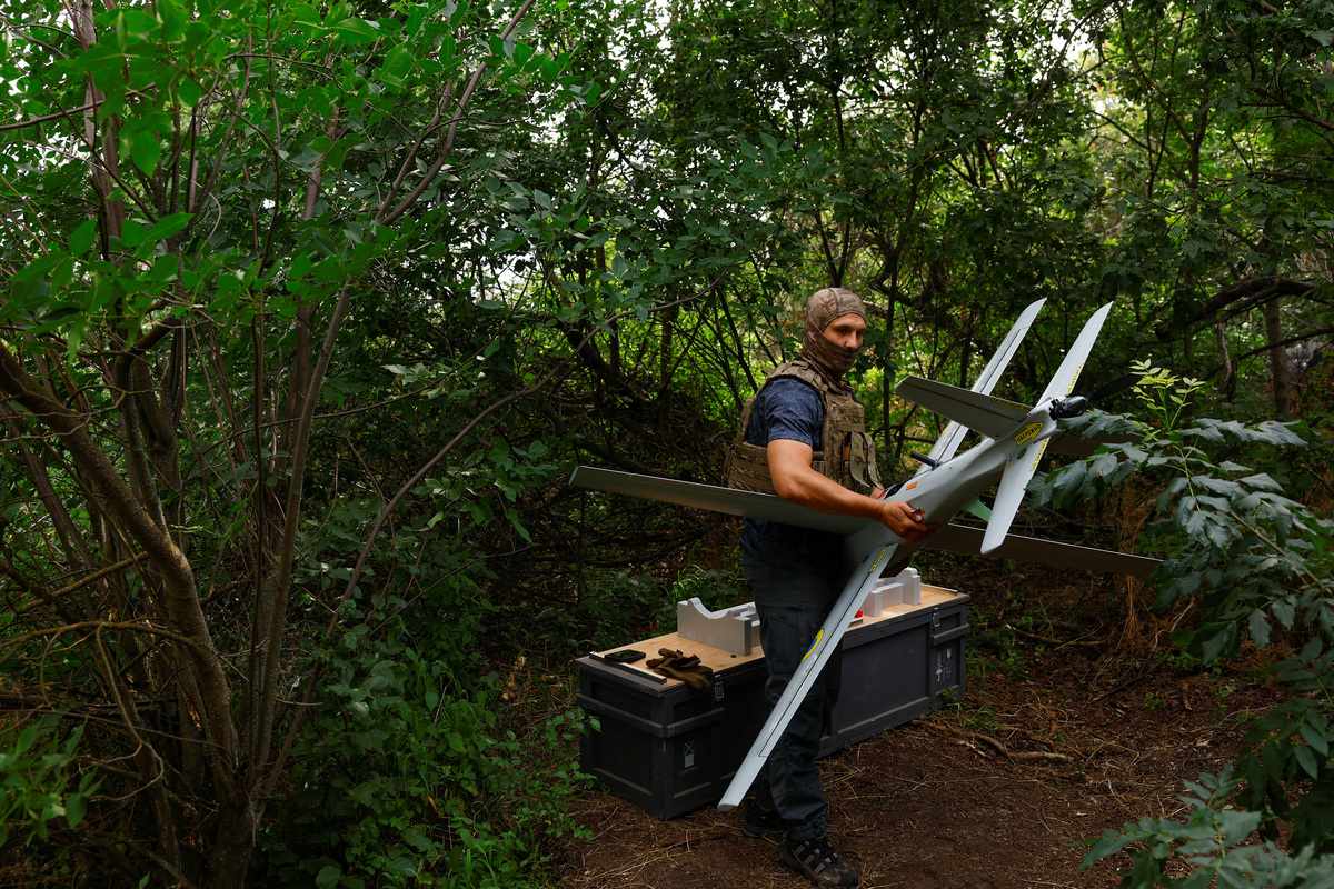 A service member of the 422nd Unmanned Systems Regiment 'Luftwaffe' of the Ukrainian Armed Forces, carries a RAM-2X strike drone to a launch point while he works at a position near a front line, amid Russia's attack on Ukraine, in an undisclosed location in Southern Ukraine, on an undisclosed date, 2026. REUTERS/Valentyn Ogirenko