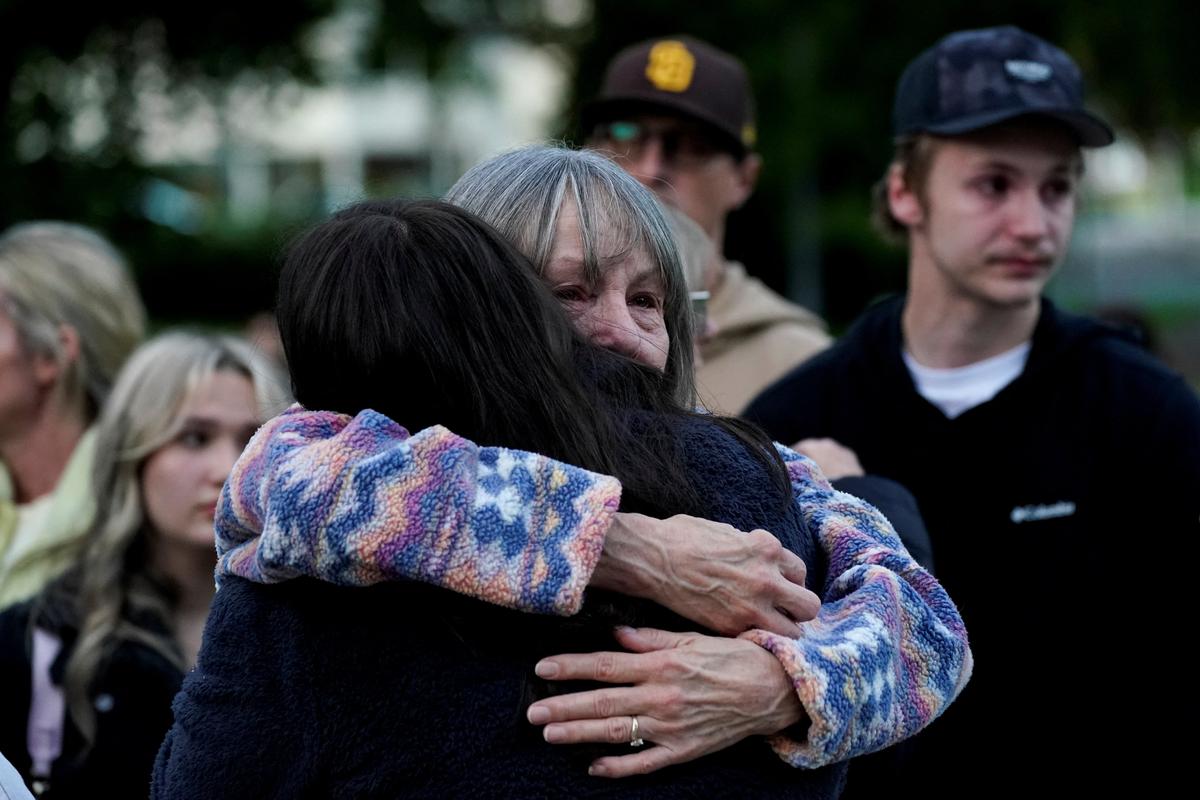 People embrace as they attend a vigil after a chemical tank rupture at the Nippon Dynawave Packaging pulp and paper mill, in Longview, Washington, U.S., May 26, 2026.  REUTERS/David Ryder