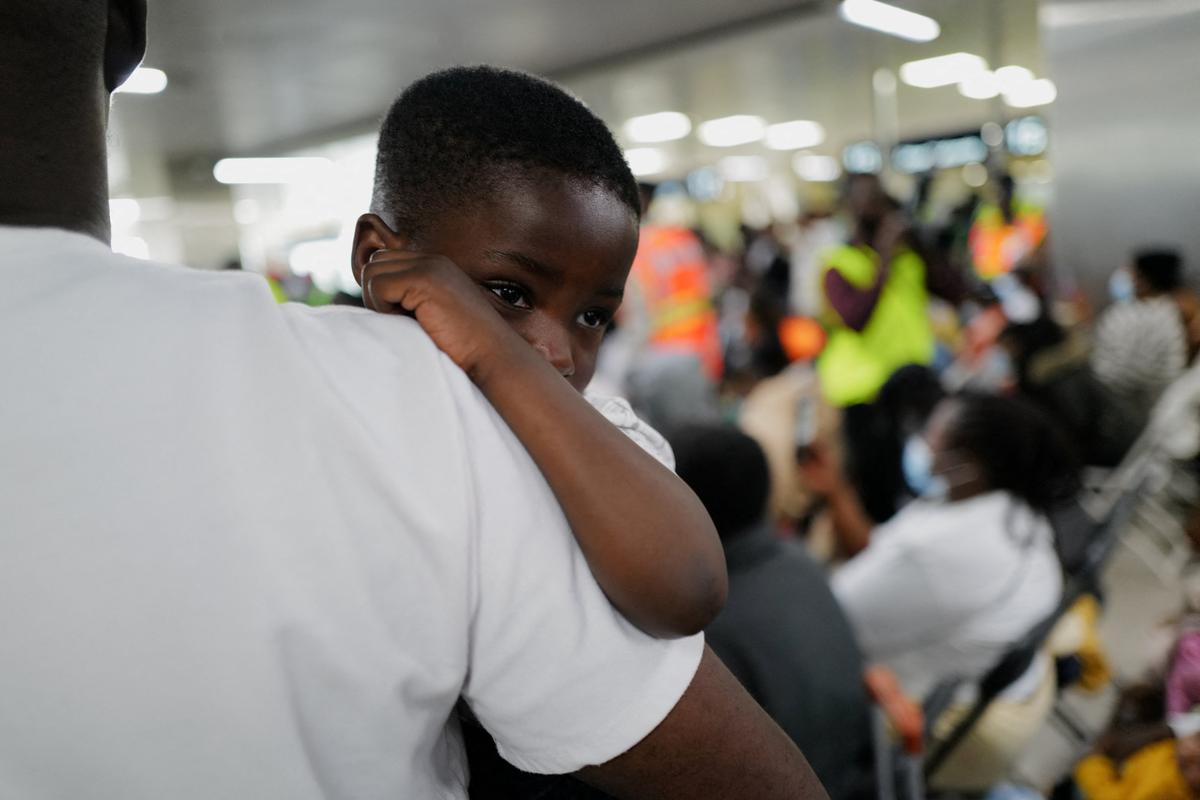 A child is carried as Ghanaian citizens arrive at the Accra International Airport as Ghana repatriates hundreds of its citizens from South Africa following instances of violence against migrants from other sub-Saharan African countries, amid a wave ‌of anti-immigration protests, in Accra, Ghana, May 27, 2026. REUTERS/Francis Kokoroko