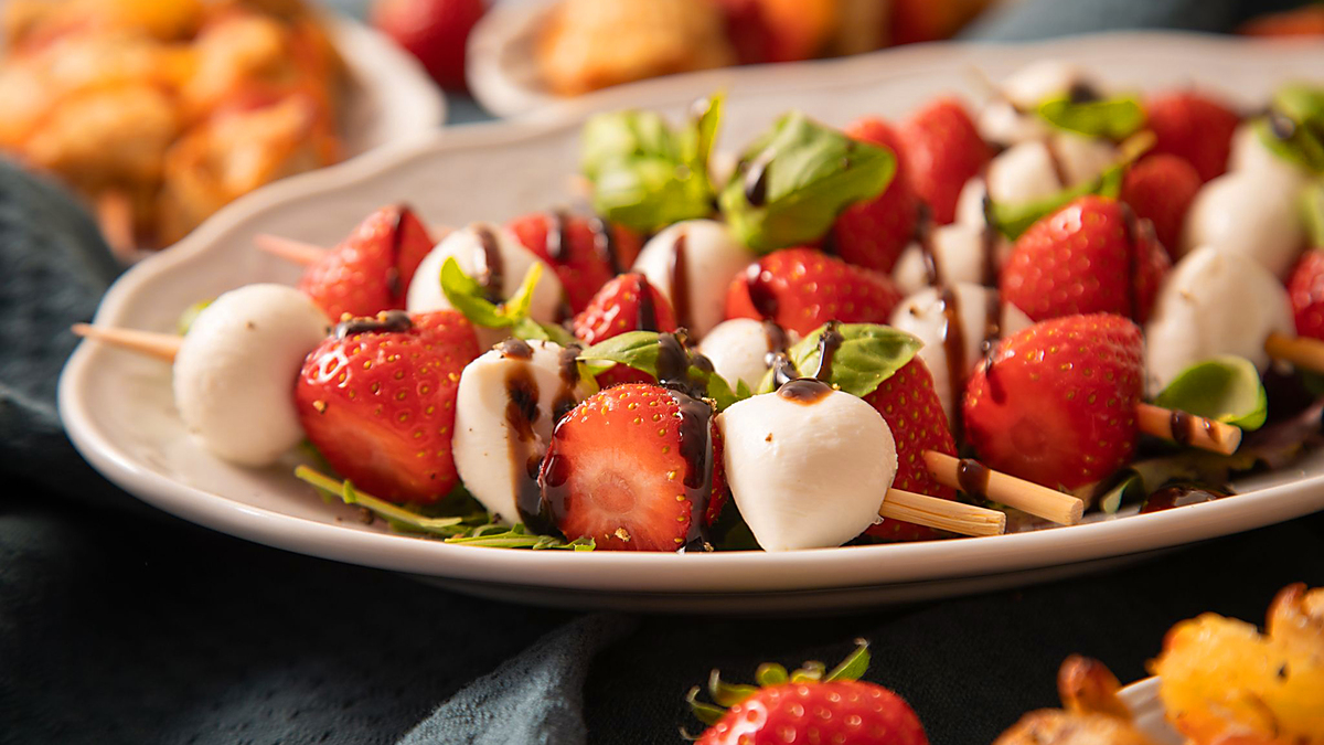 Try making these tasty mozzarella and strawberry salad sticks with basil and balsamic cream dressing.
