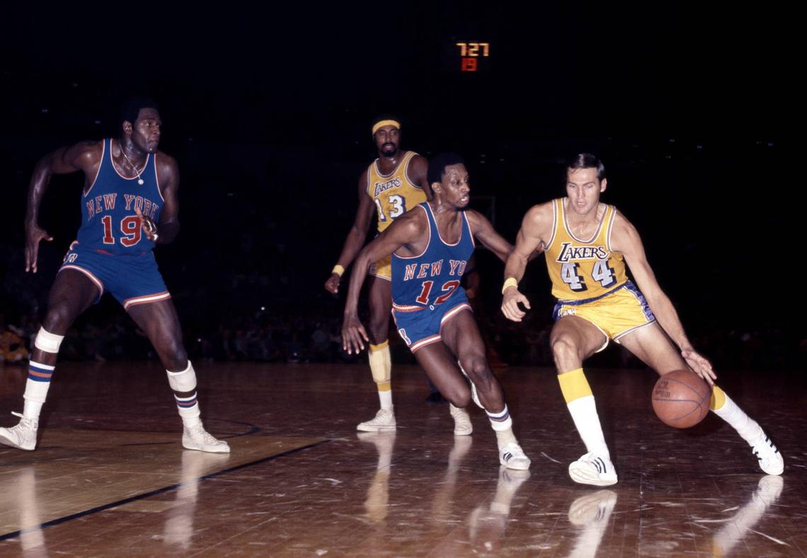  Los Angeles Lakers guard Jerry West dribbles past New York Knicks guard Dick Barnett (12) and Willis Reed (19) at The Forum. Darryl Norenberg-USA TODAY Sports